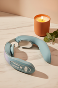 Aldera ThermaRelief Neck Massager on marble surface with eucalyptus and warm candle